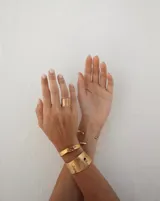 Brazalete ancho de bronce macizo con textura irregular.