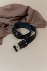 Cinturón negro de cuero con apliques de estrellas metálicas y hebilla plateada.