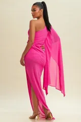 Vestido largo de fiesta color fucsia, con escote asimétrico y una sola manga larga tipo capa.