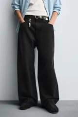 Pantalón de jeans de algodón, corte baggy fit, tiro medio, con efecto lavado en tonos grises y verdes. Presenta cinco bolsillos y cierre frontal con cremallera y botón.