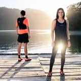 Musculosa deportiva color naranja con logo Merrell estampado en el pecho.