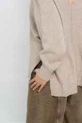 Sweater color crudo de corte holgado, con cuello redondo y terminaciones acanaladas en puños y ruedo.