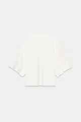 Sudadera blanca de corte holgado, cuello redondo y manga tipo capa.