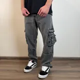 Pantalón jean gris con efecto lavado, corte holgado, bolsillos cargo laterales y costuras reforzadas en rodillas.