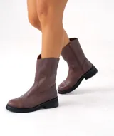 Bota de cuero vacuno color marrón, con caña media, suela de caucho y punta redonda.