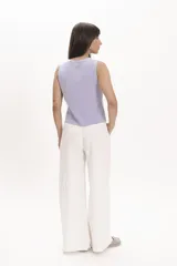 Pantalón blanco de corte palazzo, con cintura alta y pinzas delanteras.