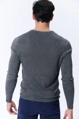 Buzo de punto gris oscuro con cuello redondo a la base.