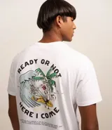 Remera blanca de algodón con cuello redondo y manga corta. Estampa en la espalda con diseño de esqueleto surfeando una ola junto a una palmera.