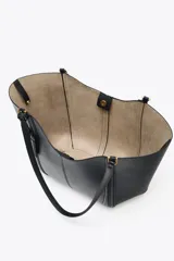 Bolso de hombro tipo shopper color beige, con doble asa y cierre imantado. Incluye una cartera interior con cierre de cremallera.