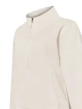 Buzo color beige de algodón orgánico, con medio cierre, cuello alto, bolsillo canguro y bordado delicado.