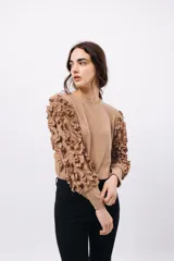 Remera negra de punto con mangas largas abullonadas con volantes.