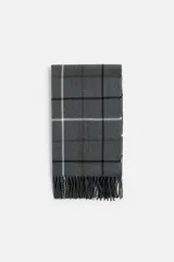 Bufanda gris con diseño a cuadros en blanco, negro y marrón. Terminaciones con flecos.