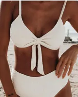 Conjunto de bikini color ocre, con corpiño tipo top con nudo central y bombacha vedetina de tiro alto.