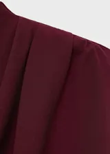 Vestido largo color borgoña, de corte recto, con cuello alto, sin mangas y detalles fruncidos.