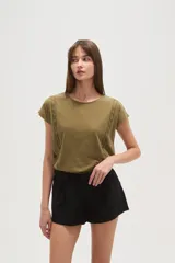 Remera color verde militar de algodón con cuello redondo y apliques de encaje en los hombros.