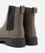 Bota Chelsea color verde oliva, confeccionada en cuero sintético, con laterales elásticos negros y suela track negra.