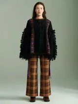Sweater negro oversize de lana con cuello redondo, bordado central en forma de trenza, laterales con cuadrillé y mangas acampanadas desflecadas.