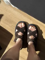 Sandalias negras de charol con tiras cruzadas y plataforma track.