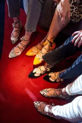 Bailarinas con estampado animal print en tonos verde y marrón, con base de napa naranja y cordones finos con borlas.