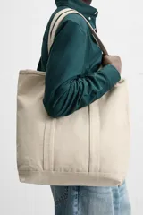 Bolso tipo shopper color crudo, fabricado en tejido de algodón. Tiene doble asa de hombro y un bolsillo interior plano.