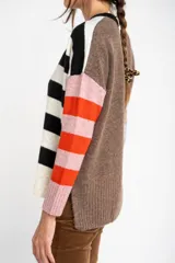 Sweater de punto con rayas en tonos naranja, morado y burdeos, de calce al cuerpo y mangas largas.