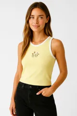 Musculosa amarilla de algodón con breteles anchos con borde blanco y bordado de flores en el pecho.