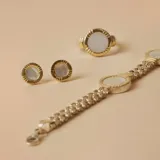 Par de aros tipo botón con base circular de plata 925 bañada en oro y centro de nácar.