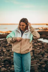 Campera color beige, blanco y verde agua con cierre frontal, cuello alto y puños elastizados.