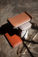 Billetera negra de cuero con cierre de cremallera, múltiples ranuras para tarjetas, compartimento para billetes y monedero con cremallera.