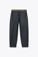 Pantalón de tiro medio con bolsillos frontales y traseros de vivo. Bajo con vuelta. Cierre frontal con cremallera, botón y cinturón trenzado.