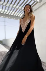 Vestido largo negro con escote en V y apliques de lentejuelas doradas en el corpiño.