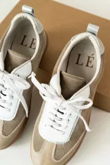 Championes marrones de cuero con cordones negros, puntera de charol y detalles dorados.