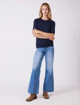 Buzo de punto fino color azul marino, con cuello redondo y mangas cortas.