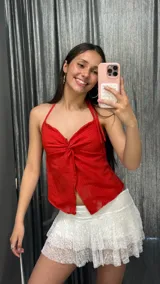 Top rojo con escote halter que se ata al cuello y al frente, dejando una abertura en el abdomen.
