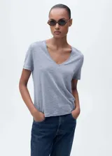 Remera color crema de lino con cuello en V y mangas cortas.
