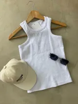 Musculosa blanca de algodón con cuello redondo y sisas amplias.