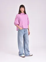 Camisa blanca de mangas 3/4 con detalles de calado en las mangas.