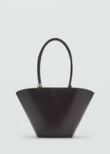 Bolso shopper negro de poliuretano con doble asa y asa de hombro. Tiene cierre de mosquetón oculto y forro interior de algodón. Incluye un bolso pequeño interior de tela.