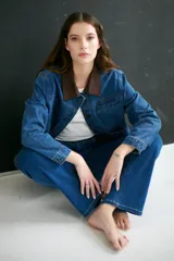 Chaqueta de jean azul con cuello marrón de pana, corte recto y bolsillos frontales.