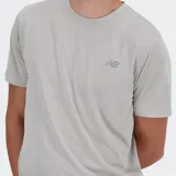 Remera deportiva New Balance de manga corta, color gris claro con textura acanalada vertical. Presenta un pequeño logo NB impreso en tono gris oscuro en el pecho izquierdo.