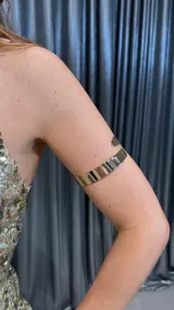 Brazalete rígido plateado para el brazo.