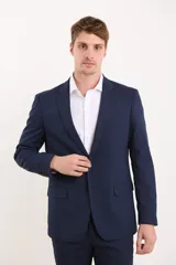 Traje de vestir azul marino, compuesto por saco de dos botones y pantalón de corte slim. Incluye camisa blanca de vestir y zapatos marrones acordonados.
