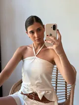 Top blanco con cuello halter y espalda descubierta.