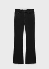 Pantalón de jean negro de tiro medio, corte ajustado hasta la rodilla y acampanado en la parte inferior, con bajo deshilachado.