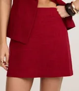 Minifalda roja de viscosa y lino, corte recto, con detalle de bolsillo falso en la parte delantera.