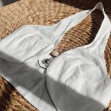 Top blanco de lino con escote halter y espalda descubierta. Se ata al cuello y a la espalda con tiras finas.