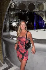 Minivestido de microtul con estampado de flores rojas sobre fondo negro.