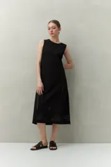 Vestido largo color beige, sin mangas, confeccionado en algodón con calados verticales y bordado tipo ojo de perdiz.