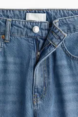 Pantalón de jean de tiro alto, corte amplio en las piernas y cinco bolsillos.