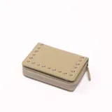 Billetera color verde con cierre de cremallera y detalle de tachas plateadas.